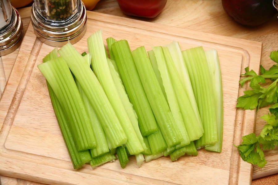 Celery stalks on a wood cutting board after growing celery in pots